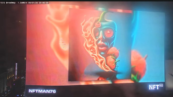 A nighttime digital billboard display showing an NFT artwork by "NFTMAN76" featuring a surreal face surrounded by flames and strawberries.