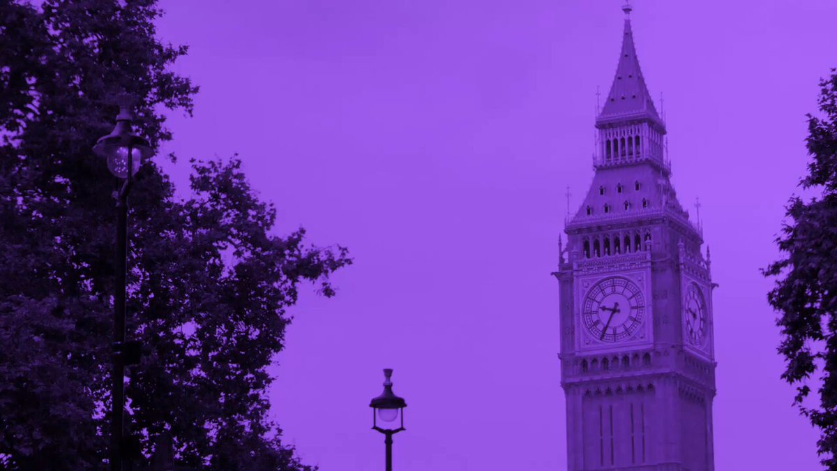 The image features a large clock tower, Big Ben, with its white face and black numbers against a purple sky background. The tower stands tall next to trees, creating an interesting contrast between man-made architecture and nature. In the foreground of the photo, there is a street lamp that adds depth to the scene. The post includes information about an event called Solana happening on June 1st, which might be related to Bitcoin or cryptocurrency.