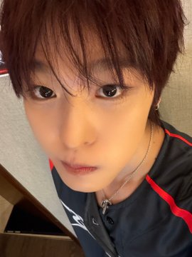 A young person with short reddish-brown hair takes a close-up selfie with a neutral expression, wearing a dark athletic top with red trim and a silver necklace. The image appears to be a casual personal photo posted alongside the text "Gemini," though no specific zodiac-related symbols or text are visible in the image itself.