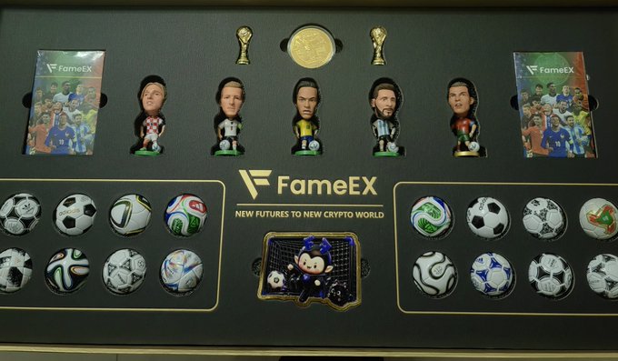 A limited-edition FameEX soccer-themed gift box displayed in sleek black and gold packaging features "Curtain Falls Five Tigers" star figurines, star-customized playing cards, miniature soccer balls, FIFA World Cup trophies, and the FameEX branding with the tagline "NEW FUTURES TO NEW CRYPTO WORLD," tying together the crypto platform's World Cup celebration giveaway.