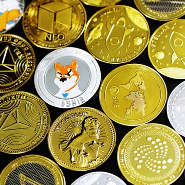 A close-up of various cryptocurrency coins featuring visible tickers and names including NEO, SHIB, Ethereum, and IOTA. The image of physical crypto tokens visually represents the institutional trading activity referenced in the post about record over-the-counter spot flow.