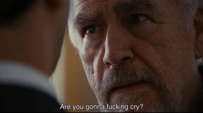 A close-up of an older man with a serious expression speaking to another person, with the subtitle reading 'Are you gonna fucking cry?'.