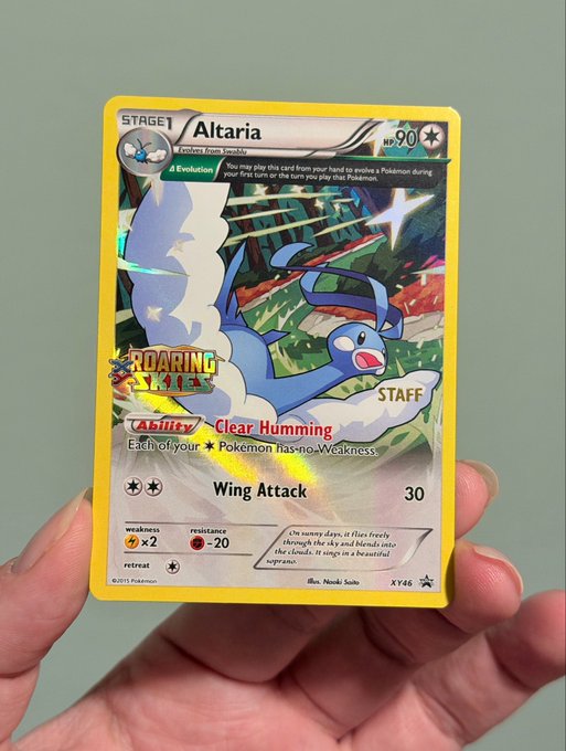 A hand holds a Pokémon trading card featuring Altaria, a Stage 1 Dragon/Fairy type with 90 HP, displaying the "Staff" prerelease stamp from the Roaring Skies set. The card's artwork shows the cloud-winged Pokémon soaring through a starry sky, matching the listing for a lightly played $90 card in a penny sleeve, top loader, and magnifying magnifier.