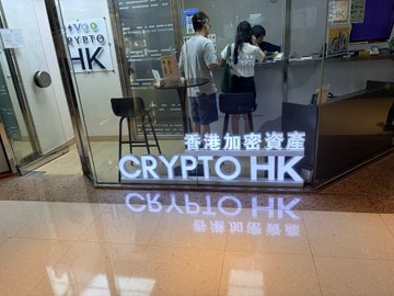 The illuminated entrance of 'CRYPTO HK' (香港加密資產) shop, reflecting on the polished floor.