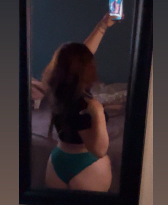 A person takes a mirror selfie in their underwear, possibly hinting at the accompanying post's content.
