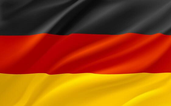 The image features a close-up view of a German flag, with its colors - red, black, and yellow - fluttering in the wind. The flag appears to be waving or blowing in the breeze, creating a sense of movement and dynamism. The background is blurred, drawing attention to the flag's vibrant colors and intricate design.