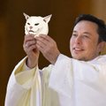 A man wearing white clothing holds up a small white cat figurine.