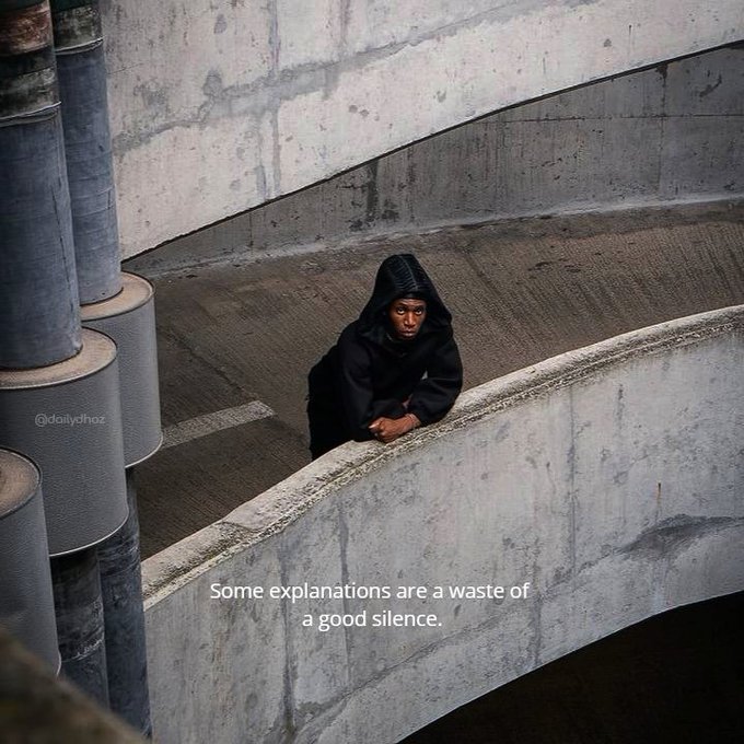 The image shows a person wearing a hoodie standing next to a curved concrete wall with columns. The caption of the image reads "Some explanations are a waste of a good silence." This quote suggests that some things may not be worth pursuing or focusing on, as they do not contribute to our overall well-being and happiness.