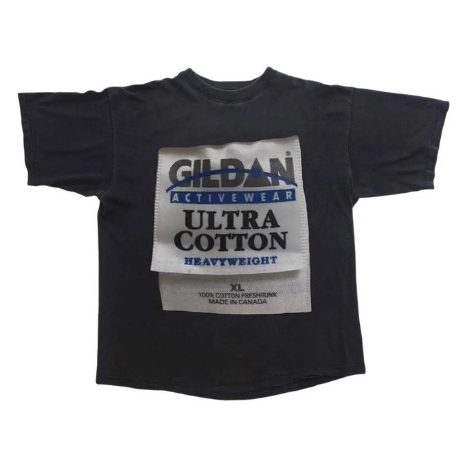 A vintage black Gildan Activewear 'Ultra Cotton' heavyweight t-shirt is displayed flat, featuring its original large front label indicating size XL, 100% cotton preshrunk, made in Canada.