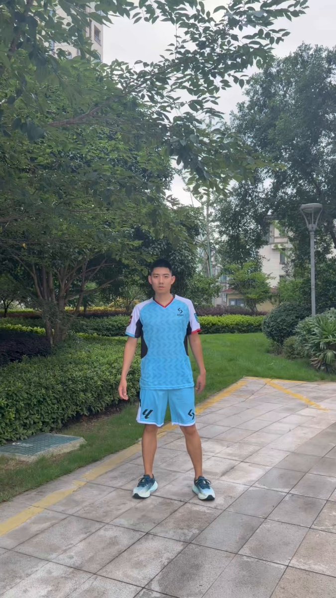 The image features a young man wearing a blue soccer uniform standing on a sidewalk, posing for a photo. The background includes trees and bushes, creating an outdoor setting. The caption of the image reads "感谢 #bitget 赞助 冲哥祝各位端午安康 同时欢迎其他品牌找冲哥拍摄".