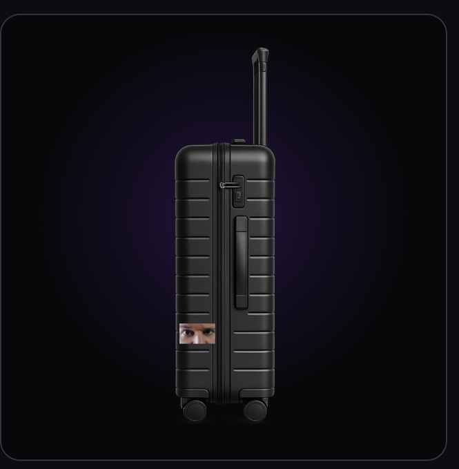 A sleek black ribbed hardshell suitcase stands upright against a dark purple gradient background, with a small face sticker affixed to its lower front section.