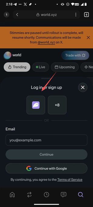 The image shows a mobile browser screenshot of the world.xyz website displaying a "Log in or sign up" screen, with options to connect via a wallet icon (likely Solflare), email, or Google, along with a notice that "Stimmies are paused until rollout is complete."

This image illustrates the post's instructions for connecting the Seeker mobile wallet, showing the login screen where users would select the wallet connection option on the world website.