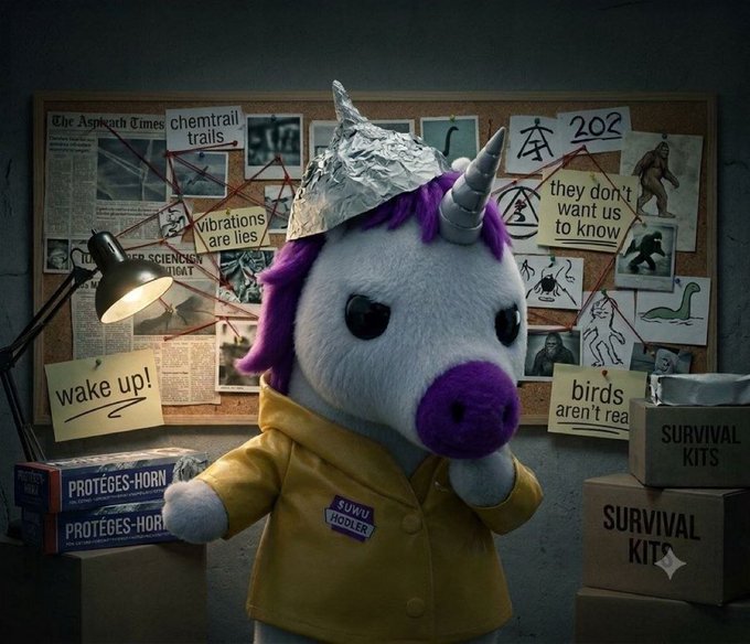 A plush unicorn wearing a tinfoil hat and a yellow "uwu hooler" jacket stands before a conspiracy-theory corkboard featuring clippings with phrases like "chemtrail trails," "they don't want us to know," "birds aren't real," and the year "202," surrounded by boxes labeled "PROTEGE'S-HORN" and "SURVIVAL KITS." The chaotic tinfoil-hat getup and wall of red-string conspiracies perfectly match the post's "schizo uwu" vibe, jokingly suggesting the mascot is deep into Solana crime investigations and lost in the lore.