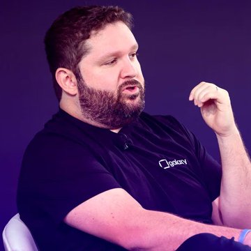 A man with a beard wearing a black Galaxy polo shirt is gesturing with his hand while speaking, appearing mid-discussion. The "Galaxy" logo is visible on his shirt, identifying him as a representative of Galaxy Digital, which connects to the post about Alex Thorn's commentary on suspicious Bitcoin activity linked to Coldcard wallets.