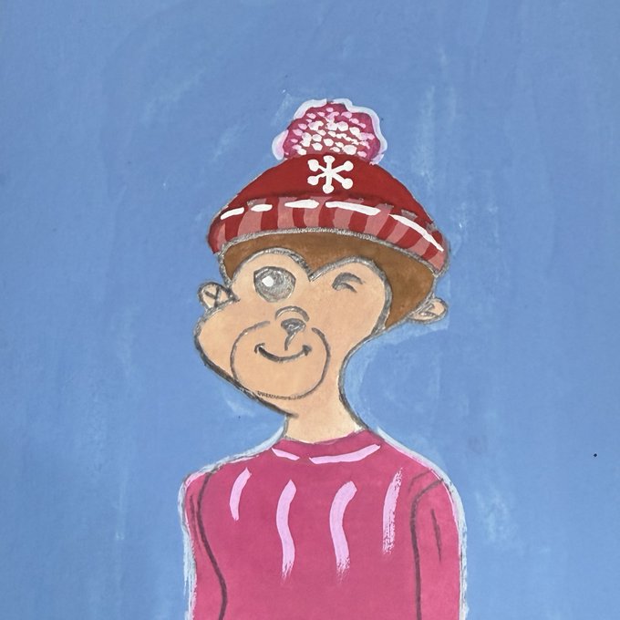 A child's drawing of a smiling figure wearing a red striped winter hat with a white snowflake and pom-pom, set against a blue chalkboard background.