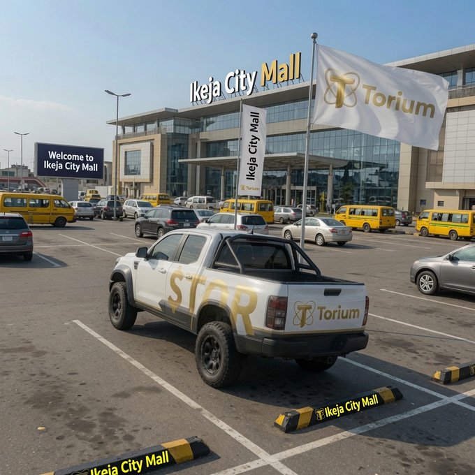 A white pickup truck branded with 'STAR' and 'Torium' logos parked in front of Ikeja City Mall, with matching Torium banners on display.
