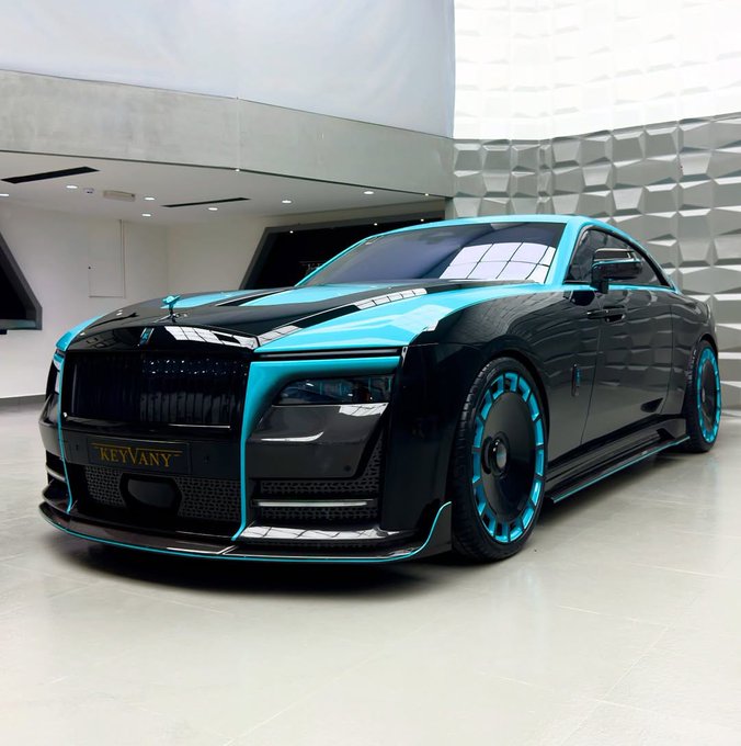 The image shows a luxury sports car with blue and black accents, including a black roof and silver wheels. The car has a large windshield and a spoiler at the back. It appears to be parked indoors, possibly in a showroom or a museum setting. The caption reads "Gm, Gquack friends Spent some time thinking about @wallchain today... And I think the most interesting projects aren'". This suggests that the car's design and features might have been inspired by the concept of Wallchain Select, which is an online platform for showcasing unique and innovative automotive designs. The image highlights the creativity and attention to detail in the development of luxury sports cars.
