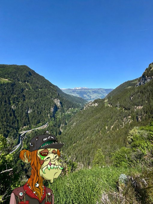iced coffee cup with a green lid, featuring a cartoon monkey and mountain range backdrop.