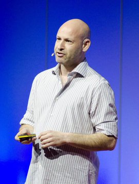 The image features a bald man wearing a striped shirt, standing against a blue background with his hands behind his back. He appears to be giving a speech or presentation, as indicated by him holding a cell phone up to his ear. The caption of the image reads "This is exactly what Cardano and Midnight teams have been working towards. These guys are playing catch up. $NIGHT is the future." This suggests that the man might be discussing the concept of Bitcoin and its potential impact on the financial world, as suggested by the reference to Cardano and Midnight.