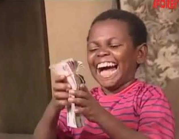 A young boy in a red and white striped shirt laughing joyfully while holding a thick stack of paper currency, with 'AFOREV' watermark in the top right corner.