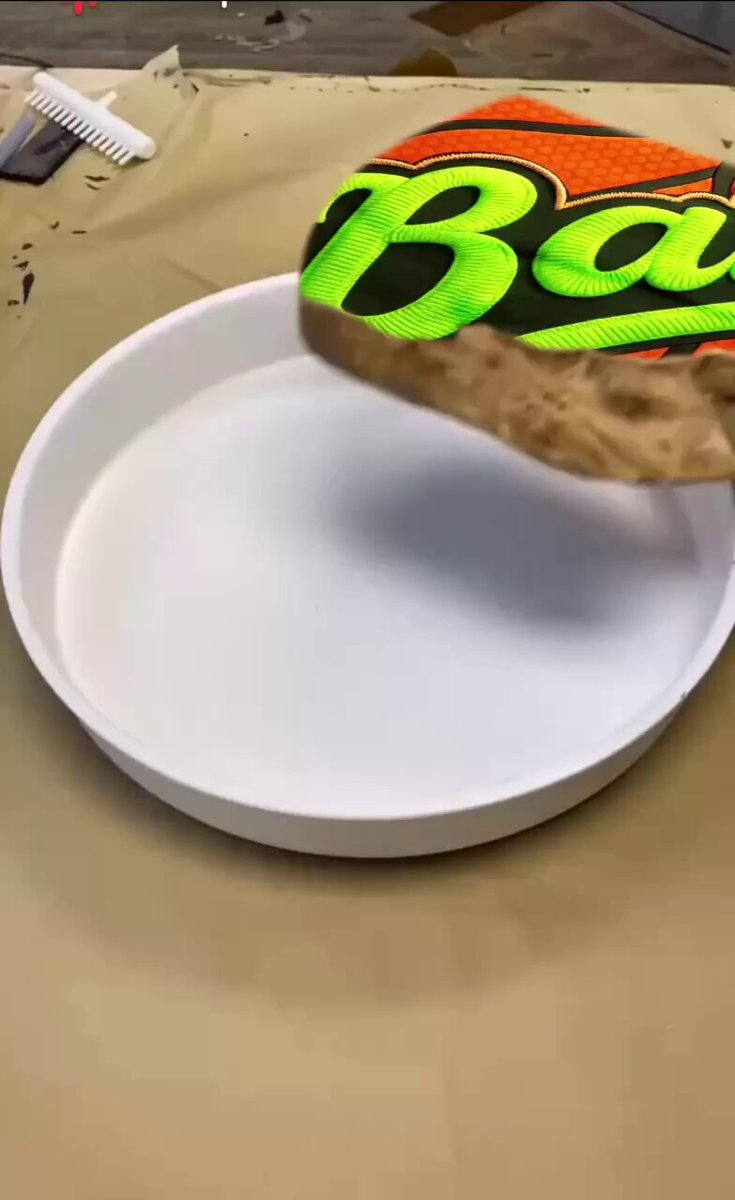 The image features a white plate with an orange and green label that says "Balln Token!". The plate has a small piece of food, possibly a slice of pizza or a cookie, placed on top of it. The background appears to be a tablecloth with some writing visible in the corner. The post is about sports tokens and mentions the Balln token as an example.