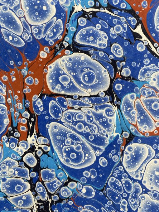 An abstract marbled painting featuring swirling patterns of blue, white, and rust-orange with bubble-like circular textures.
