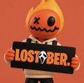 A cheerful pumpkin-headed character holds a black sign reading "LOST▼BER" with a "Tuesday" sticker, nodding to the post's Taco Tuesday theme. The image ties together the holiday celebration with the referenced NFT project, highlighting the "OG" Lost Bear community still actively pushing its IP.