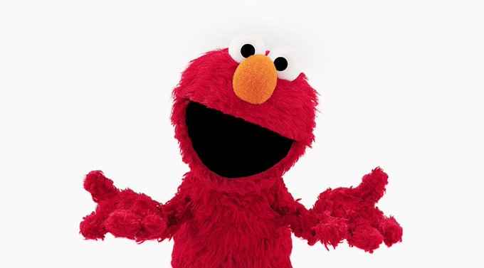 A red Elmo plush toy with its arms raised and mouth open, photographed against a white background.