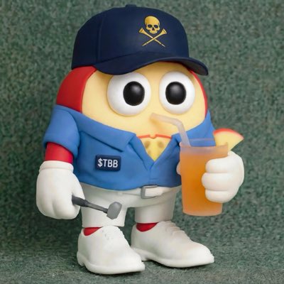 A toy figure of a Humpty Dumpty-style egg character dressed in a blue uniform and cap with a skull logo, holding a hammer and a drink, with '$TBB' on its chest.