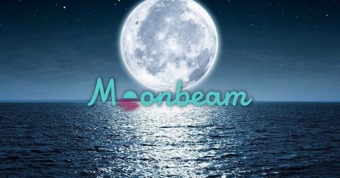 The user wants a concise caption describing the image.
I need to identify the key visual elements:
- A large, bright full moon in a night sky.
- A starry sky.
- A body of water (ocean/sea) reflecting the moonlight.
- Text overlaid on the image: "Moonbeam" in a teal, cursive font.

I also need to consider the context provided in the prompt ("The accompanying post says..."). The prompt asks for a caption that describes what is *in* the image, but also mentions the text visible. The text "Moonbeam" is clearly visible.

So, the caption should mention the moon, the water, and the text "Moonbeam".

Drafting the caption:
- "A large full moon shines over a dark ocean with the text 'Moonbeam' overlaid in teal."
- Or more simply: "A night scene featuring a large full moon over the ocean with the word 'Moonbeam' written across the