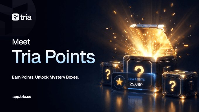 The image features a large golden box filled with gold coins, surrounded by small cubes containing questions or hints about the game. The text "meet Tria Points" is displayed above the golden box, while the text "apptria.io" is below it. The background of the image is black and has sparks flying out from it, creating a sense of mystery and excitement around the treasure chest.