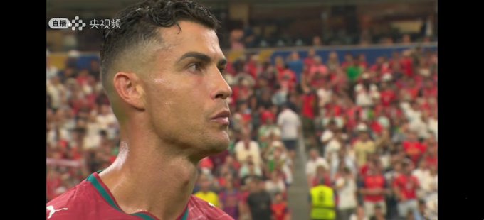 Cristiano Ronaldo, wearing Portugal's red jersey, stands solemnly in a stadium filled with fans, with the CCTV broadcast logo visible in the upper corner, capturing his emotional reaction during the final moments of Portugal's World Cup elimination by the Netherlands.