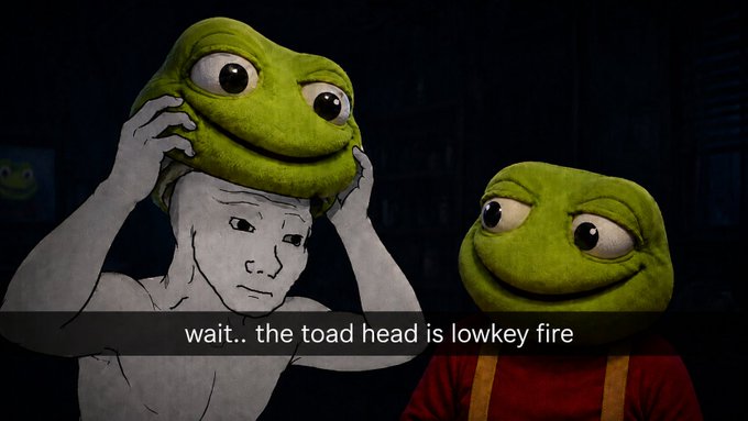 Two frog-like toad-headed characters stand in a dimly lit room, with the left figure adjusting its oversized toad mask over a human face, accompanied by the caption "wait.. the toad head is lowkey fire" — humorously illustrating the joke that the coolness belongs to the toad, not the wearer.