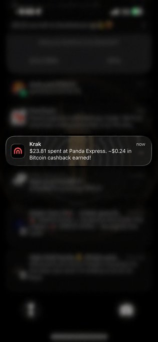 A mobile notification from the Krak app displays a message stating "$23.81 spent at Panda Express, ~$0.24 in Bitcoin cashback earned!" timestamped "now," illustrating the cashback reward referenced in the accompanying post about earning Bitcoin back on purchases.