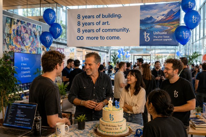 Tezos community members celebrate the blockchain's 8th birthday at a gathering featuring a banner reading "8 years of building. 8 years of art. 8 years of community. ∞ more to come." alongside Ushuaia, "The 21st Tezos protocol upgrade," with attendees gathered around a birthday cake decorated with the Tezos logo.