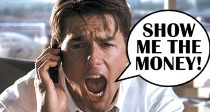 The image shows a man (Tom Cruise) shouting "SHOW ME THE MONEY!" into a phone, used here to mock a wallet's narrative symbolism. The reference satirizes how the wallet's branding borrows from the "Robin Hood" Robinhood theme, implying it's just dressed-up marketing around its USG/USDG stablecoin pairing.