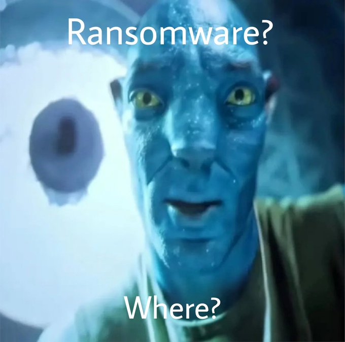 A blue Na'vi character from Avatar looks wide-eyed and alarmed, with the text "Ransomware?" at the top and "Where?" at the bottom. The meme humorously captures the panicked reaction of investors who, after experiencing initial confidence and gains in the market, suddenly worry about unexpected threats like ransomware attacks wiping out their profits—mirroring the Vietnamese post's point about how quickly investor psychology shifts from feeling like a genius to fearing sudden losses.