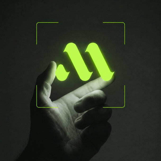 A hand holds up a glowing neon green "M" logo framed by camera brackets against a dark background, symbolizing focus and precision. The bold illuminated letter paired with the tagline "Less noise. More shipping. Ready?" visually conveys a message of zeroing in on what truly matters—cutting distractions and delivering results.