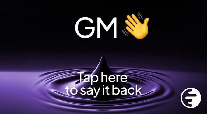 A dark purple promotional graphic with 'GM' text, a waving hand emoji, and 'Tap here to say it back' over a water droplet image, with a sign language app logo.