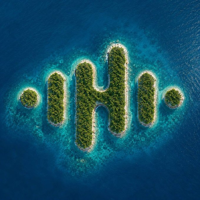 An aerial view of tropical islands arranged to form the shape of the Ethereum logo, surrounded by turquoise waters and coral reefs.