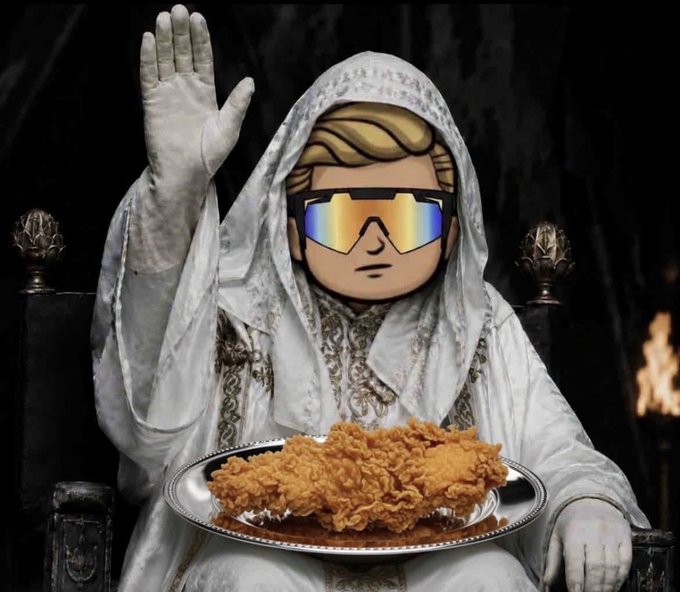 A surreal edited image depicts a figure wearing a white hooded robe and traditional Islamic headwear, but with a cartoonish face wearing reflective sunglasses, holding a platter of fried chicken on a throne.