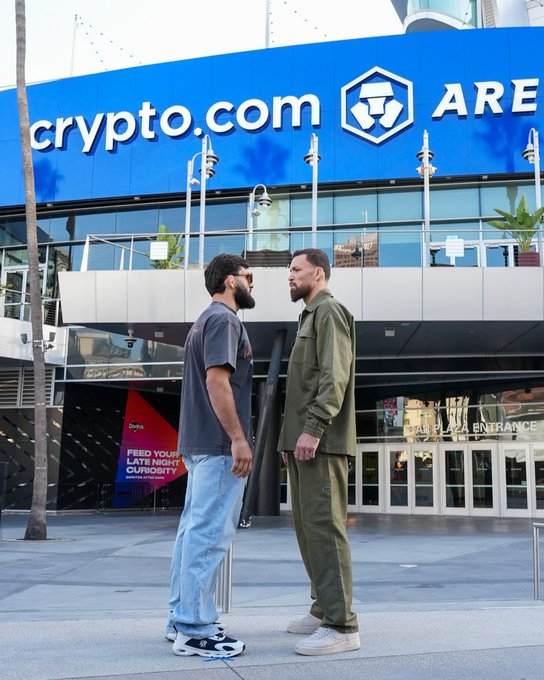 Two men face each other in front of the Crypto.com Arena, with signage reading "crypto.com ARENA" and "PLAZA ENTRANCE" visible, teasing the Arman Tsarukyan vs. Mateusz Gamrot UFC 311 matchup airing on Paramount+. The image promotes the upcoming bout set for September 19 at 9pm ET.