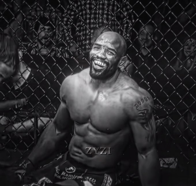 A black-and-white digital illustration of a muscular, smiling MMA fighter inside a cage with a watermark reading 'ZYZI'.