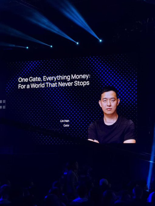 Dr. Lin Han (Dr. Han) appears on a large stage screen at TOKEN2049 in Bali, unveiling "Gate Money" with the tagline "One Gate, Everything Money: For a World That Never Stops," illustrating the post's description of Gate's latest financial product reveal.