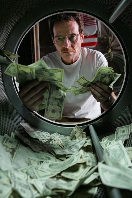 A scene from the TV show Breaking Bad showing Walter White counting money inside what appears to be a washing machine or dryer.
