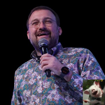 The image features a man wearing glasses, a floral shirt, and holding a microphone while standing on stage. In the background of the photo, there's an image of a pig with a caption that reads "#Cardano founder Charles Hoskinson says he' s taking a break" and "holidays in Israel". The man is smiling at the camera, indicating that he is enjoying himself during his time on stage.