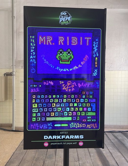 The image features a large sign with a cartoon frog on it that says "Mr. RIT" and has a picture of a frog on it. The sign also includes text about an artist named Dark Farms, which suggests that there might be some sort of art exhibit or event related to the Frogs collection at Dark Farms.