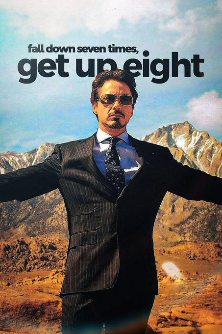 The image features a man dressed in a suit standing in front of a mountain range with his arms outstretched. The caption reads "fall down seven times, get uneight", which seems to be a reference to the movie Iron Man. The background includes mountains and trees, creating an outdoor setting for the scene.