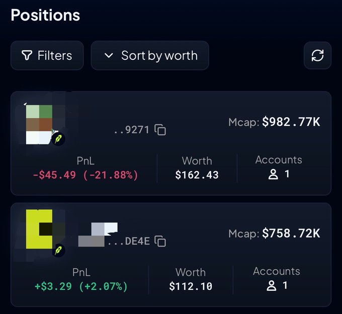 A trading portfolio screen showing positions sorted by worth, with one entry (ending in 9271) showing a Mcap of $982.77K, PnL of -$45.49 (-21.88%), and Worth of $162.43, and another (ending in DE4E) showing Mcap of $758.72K, PnL of +$3.29 (+2.07%), and Worth of $112.10.