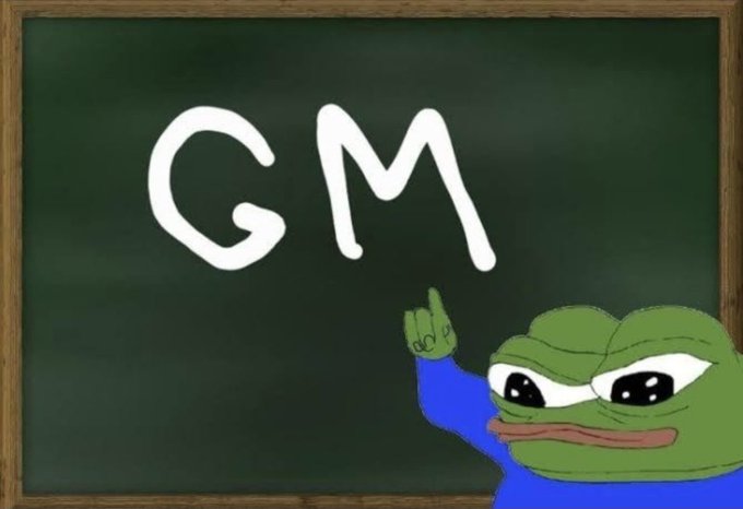 A Sad Pepe frog meme pointing at a chalkboard with 'GM' (Good Morning) written in white.